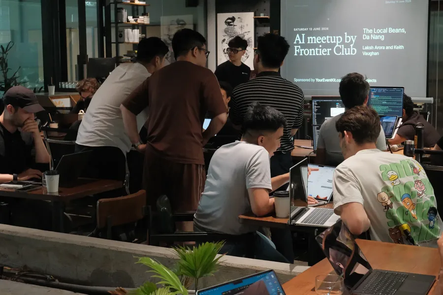 A crowded AI meetup with people working on laptops