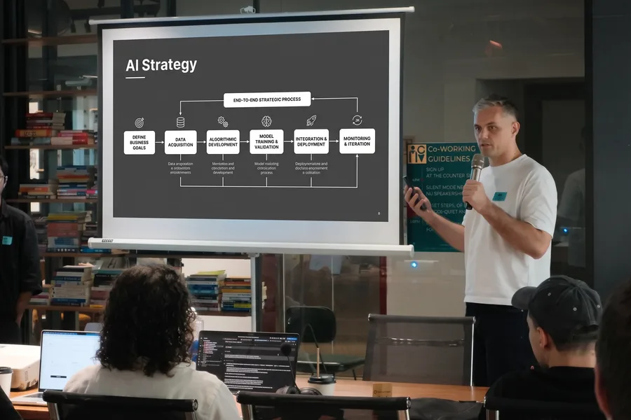 Presenting beside a projector at an AI learning event